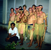 Wilcommen, No. 0010 Lino Olopai Kneels In Front of Troupe of Non-Carolinian Men in Mwáár and Traditional Coconut Leaf Dress